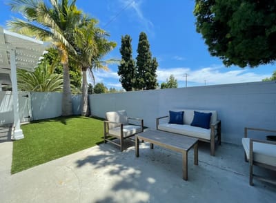 Outdoor seating area with palm trees and blue cushions