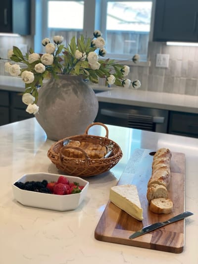 A beautifully arranged cheese and fruit platter on a kitchen counter