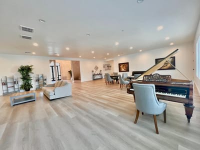Bright and spacious common area with seating and a piano