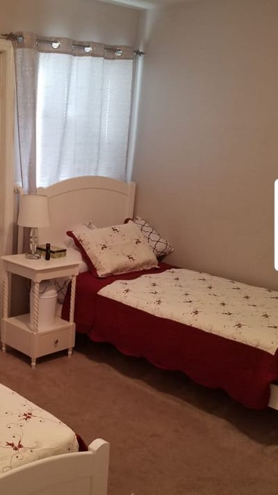 Cozy resident room with twin beds and bedside table