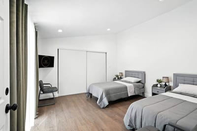 A bright, modern shared resident room with two beds