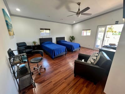 A shared resident room with two beds and seating area