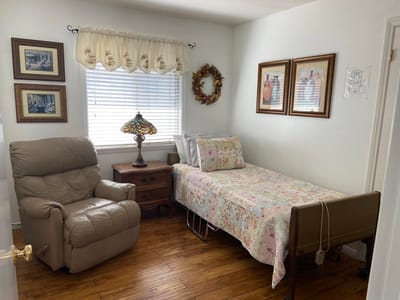 Cozy resident room with bed and armchair