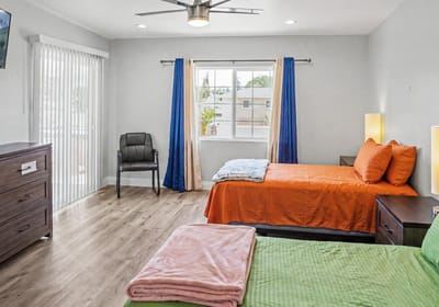 Well-lit interior view of a shared living space with two beds