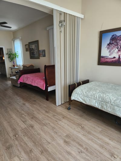 A brightly lit resident room with beds and decor