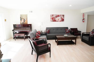 Bright common area with seating and a piano