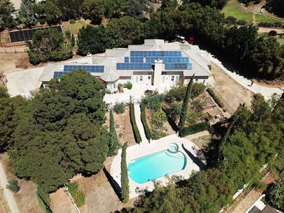 Aerial view of the facility with a pool and gardens