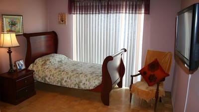 A private resident room with a bed and chair