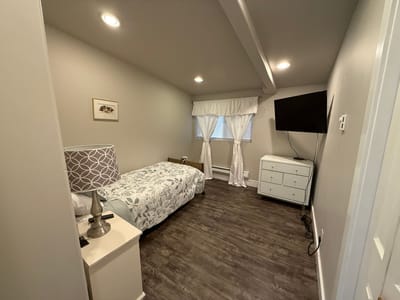 A well-furnished private resident room with bed and dresser