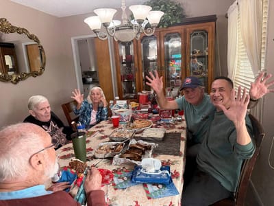 Residents celebrating around a dining table with food