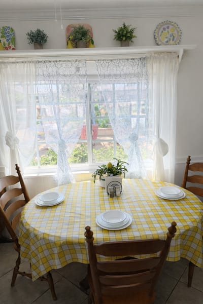 Bright dining area with a yellow checkered tablecloth and plants