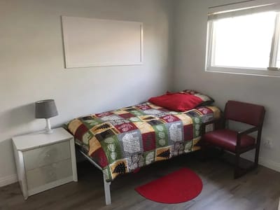A private resident room with a bed and chair
