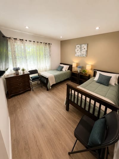 Shared resident room with two beds and natural light
