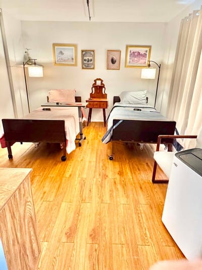 A well-furnished resident room with two beds and decor