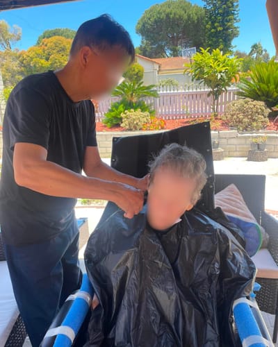 A resident getting a haircut outdoors