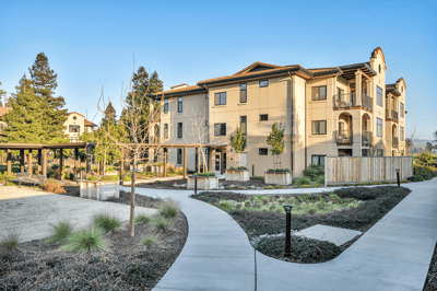 Exterior view of a senior living community with pathways and landscaping.