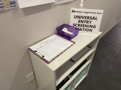 Entry screening station with facility signage.