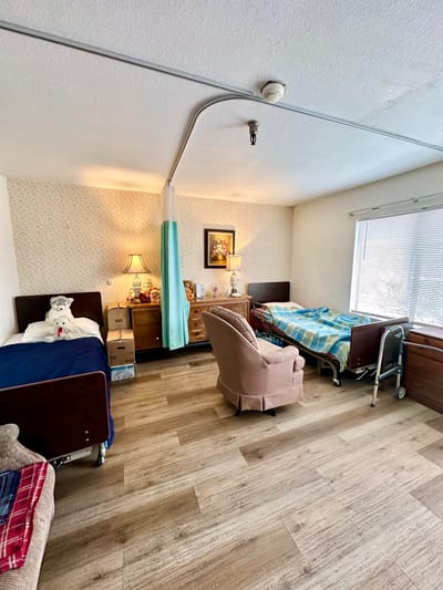 Private room in an assisted living facility with beds and furniture