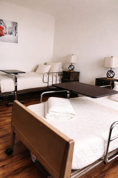 A well-furnished resident room with beds and lamps