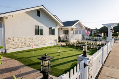 Exterior view of a senior living cottage with putting green