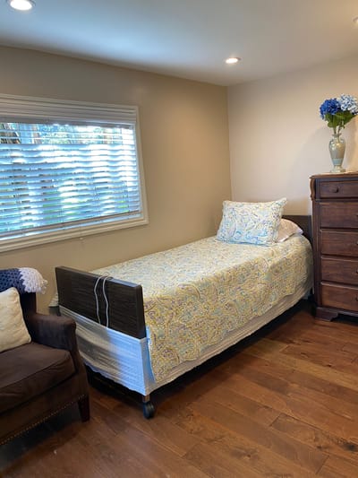 A cozy private resident room with a bed and dresser