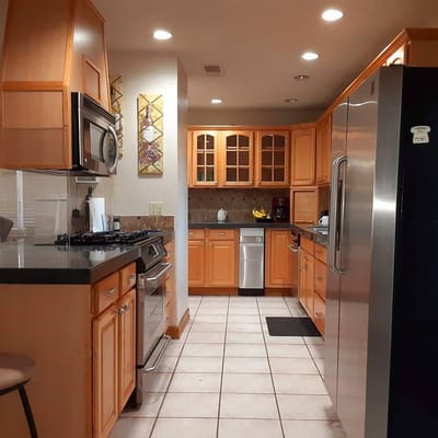 Bright kitchen with wooden cabinetry and appliances
