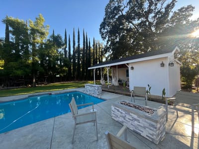 Outdoor pool area with seating and greenery