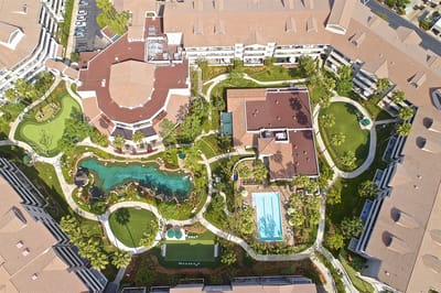 Aerial view of the facility with landscaped gardens and pool