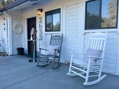 Rocking chairs on a porch outside a building entrance
