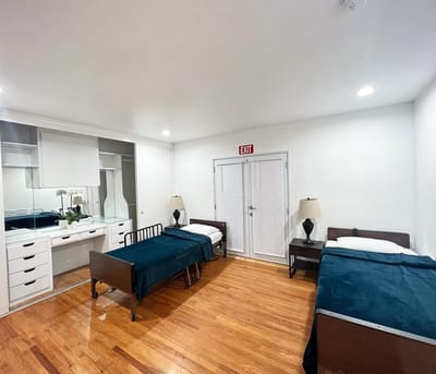 A private resident room with two beds and a wardrobe