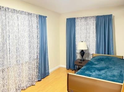 Cozy resident room with light curtains and a lamp