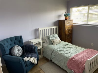 Cozy resident bedroom with a bed and armchair