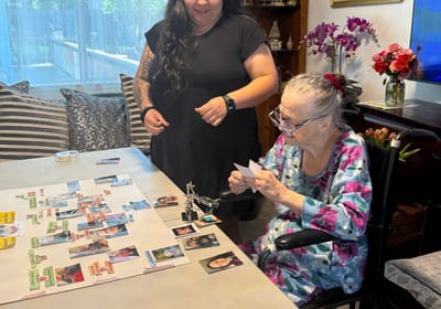 Staff member assisting resident with a craft activity