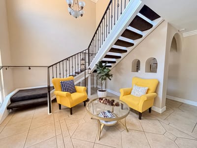 Bright lobby area with yellow chairs and staircase