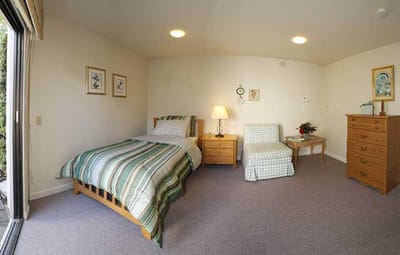 Cozy private resident room with a bed and chair