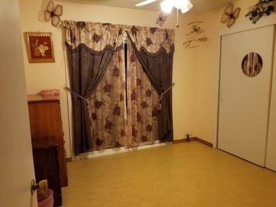 A simple room with curtains and wooden furniture