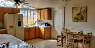 Bright kitchen area with wooden cabinetry and dining table