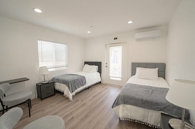 Brightly lit shared resident room with two beds