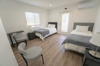 A spacious shared resident room with two beds