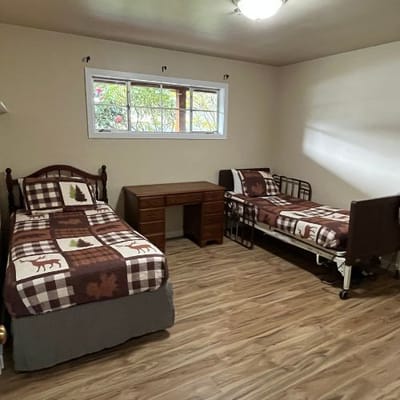 A shared bedroom with two beds and a desk