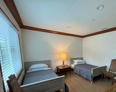 A shared resident room with two beds and a lamp