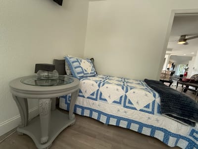 Cozy resident room with a quilted bed and table