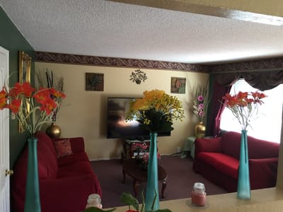 Cozy interior common area with red couches and flowers