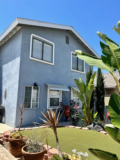 Exterior view of a blue building with landscaping