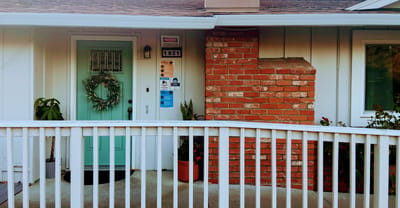 Entrance of Serene Meadow Homes with brick and teal door