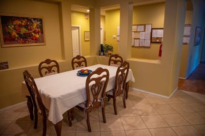 Dining area with a large table and fruit centerpiece