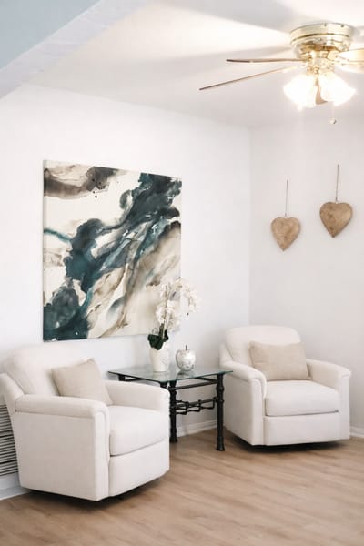 Cozy sitting area with two chairs and artwork