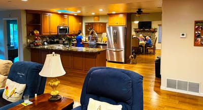 Bright kitchen area with residents and staff engaging in activities