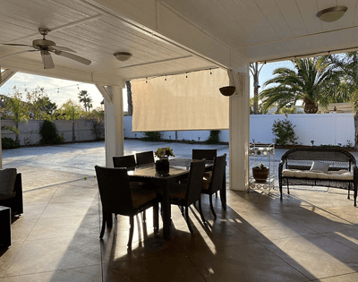 Outdoor dining area with chairs and table under patio