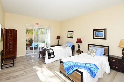 Bright resident room with two beds and outdoor view